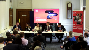 Developments in UK fusion energy: Skills, industry and the state of play’ convened by Assystem. Five people at a table in front of an audience with a projection screen behind them